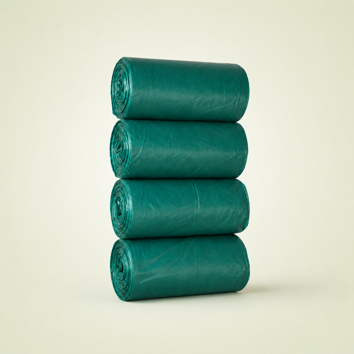 Four green trash bags stacked on a beige background