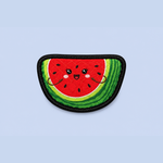 A watermelon slice patch with a cute cartoon face, featuring red flesh, green striped rind, and black seeds, set against a solid light blue background.